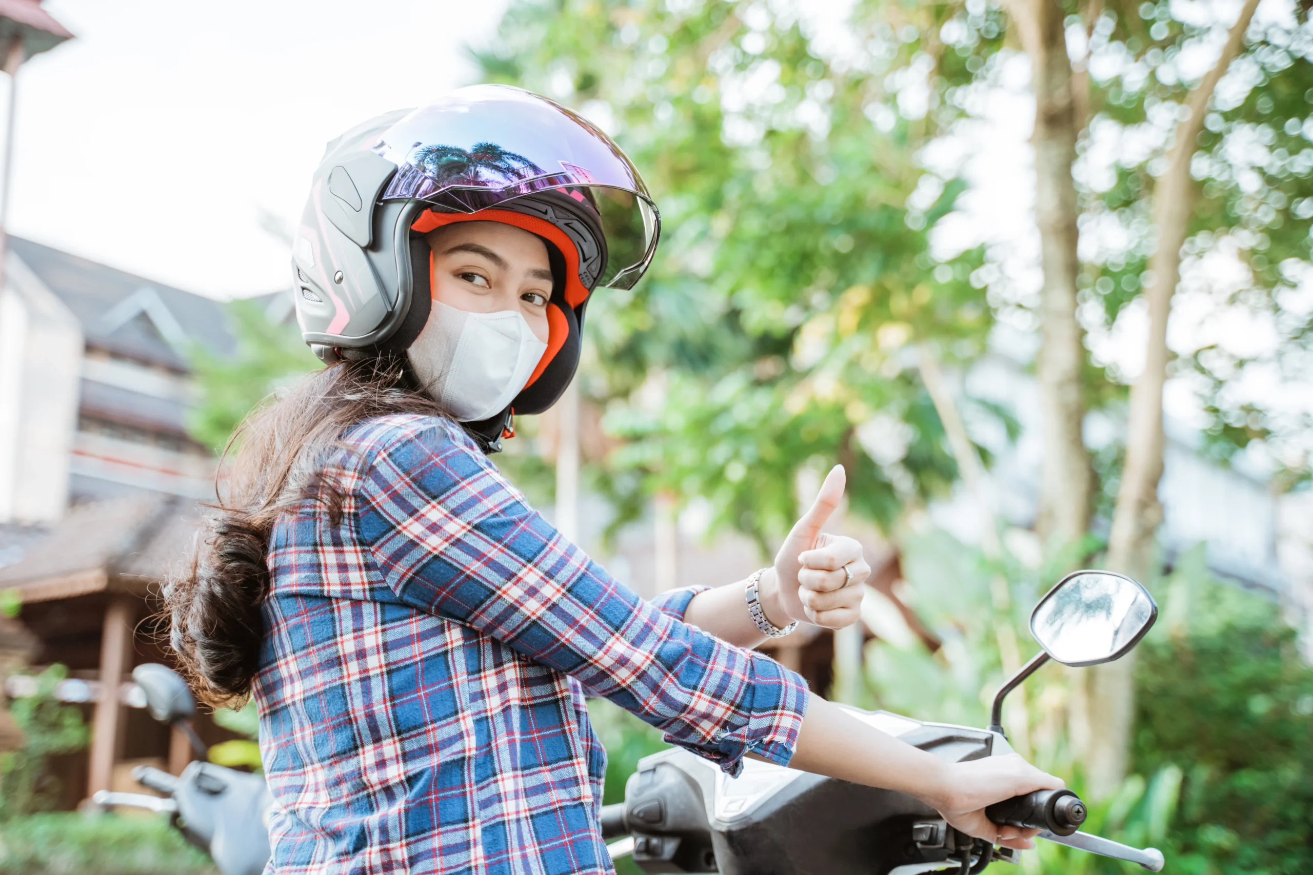 180594668_l woman wearing helmet and mask with thumbs up while riding